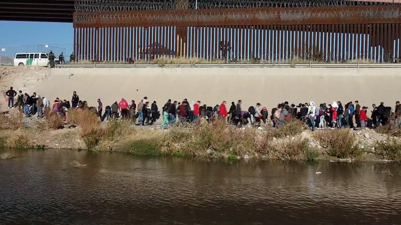 大批无证移民聚集美墨边境墙等待庇护